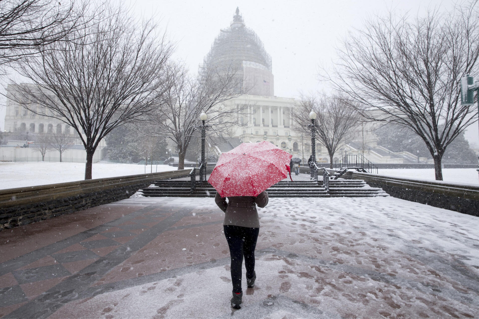 Fotografía de archivo de una mujer en medio de la nieve frente al Capitalio,