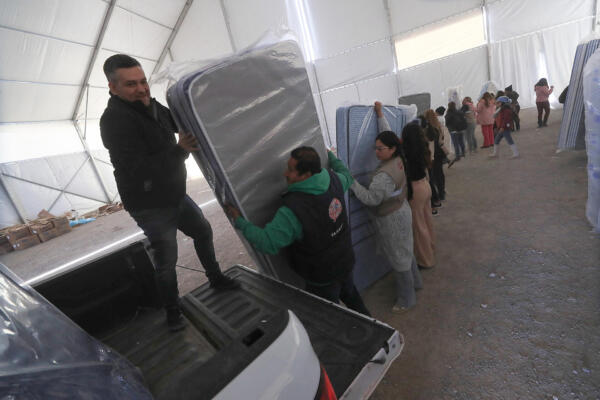 Trabajadores descargan colchones para la llegada de migrantes deportados, en Ciudad Juárez, Chihuahua (México). 
EFE/ Luis Torres