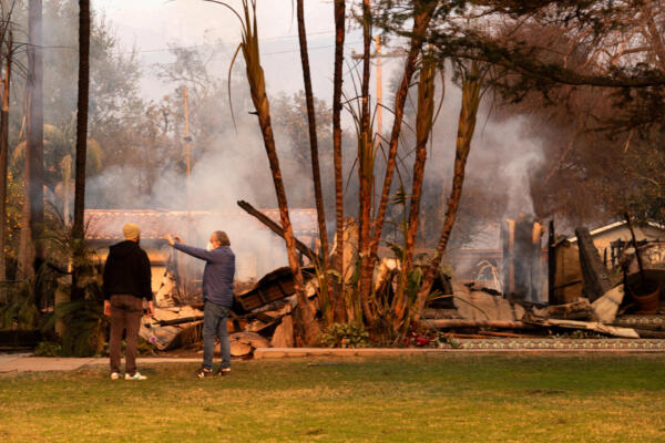 Personas observan una casa afectada por un incendio en Altadena, California (Estados Unidos). 
EFE/ Ana Milena Varón