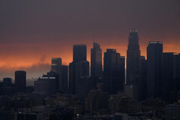 An aerial image shows smoke (L) from the Palisades Fire rising behind the downtown Los Angeles skyline as the city is covered in a haze from wildfires raging around Los Angeles, California on January 8, 2025. - At least five people are now known to have died in wildfires raging around Los Angeles, with more deaths feared, law enforcement said January 8, as terrifying blazes leveled whole streets, torching cars and houses in minutes.
More than 1,000 buildings have burned in multiple wildfires that have erupted around America's second biggest city, forcing tens of thousands of people from their homes. (Photo by Patrick T. Fallon / AFP)