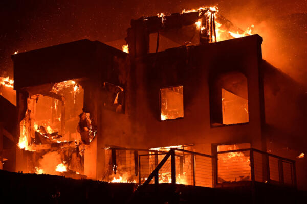 A house is engulfed in flames as the Palisades Fire burns along Pacific Coast Highway in Malibu, California, on January 8, 2025. - At least five people have been killed in wildfires rampaging around Los Angeles, officials said on January 8, with firefighters overwhelmed by the speed and ferocity of multiple blazes -- including in Hollywood. (Photo by AGUSTIN PAULLIER / AFP)