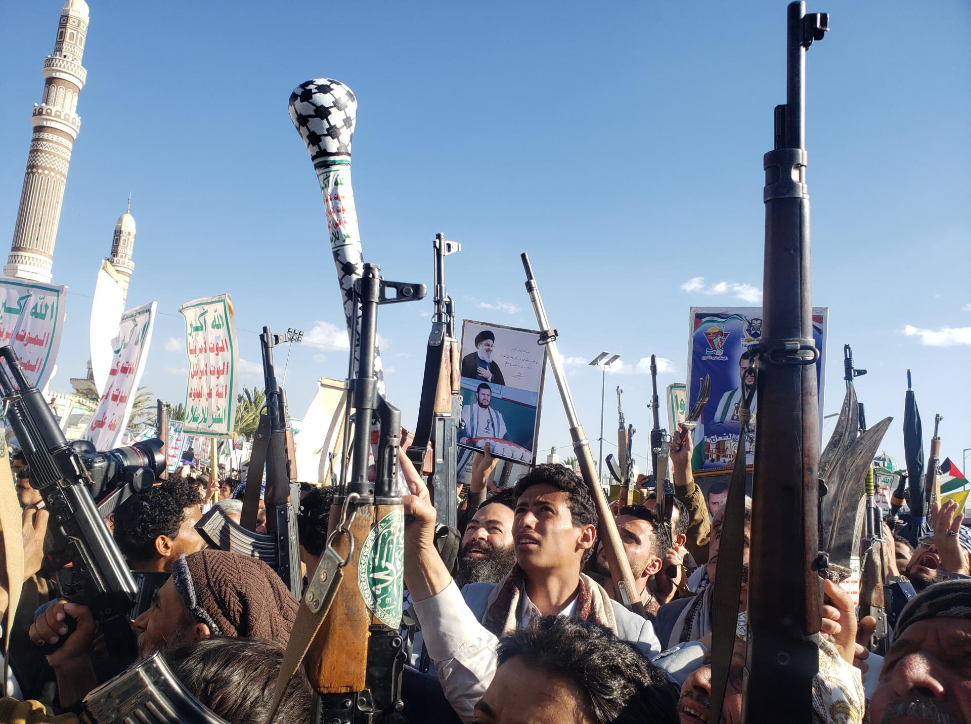 Los partidarios de los hutíes levantan sus armas durante una protesta antiestadounidense y antiisraelí en Saná, Yemen