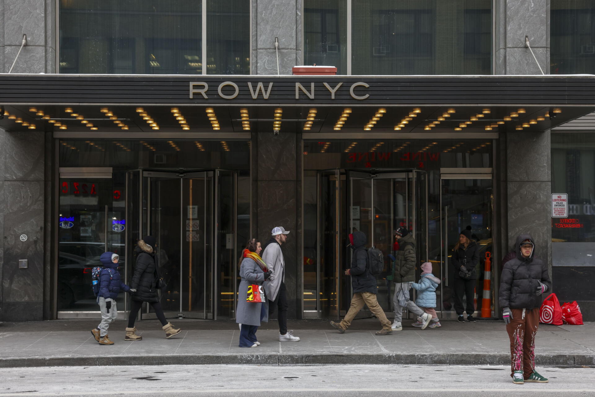 La gente pasa junto a un refugio de migrantes en el antiguo Hotel Row NYC en Nueva York, Nueva York