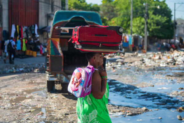 Fotografía de archivo de una mujer caminando con sus pertenencias en una calle de Poste Marchand, en Puerto Príncipe (Haití).