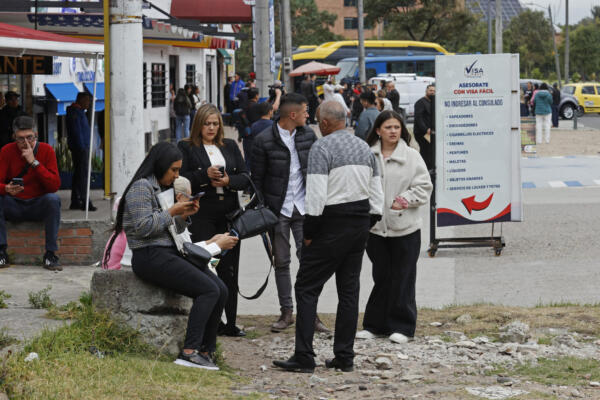 Ciudadanos colombianos solicitantes de visa de los Estados Unidos esperan información cerca a la sede de la embajada de los Estados Unidos en Bogotá. 
EFE/ Mauricio Dueñas 