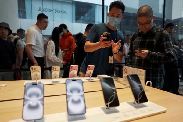 FILE PHOTO: A staff member attends to a customer as the new iPhone 16 series smartphones go on sale at an Apple store in Beijing, China September 20, 2024. REUTERS/Florence Lo/File Photo