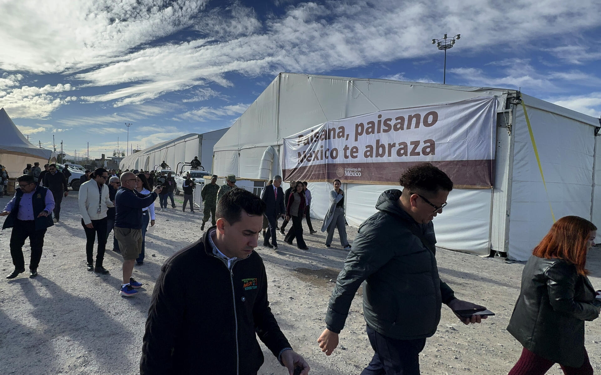 Personas caminan frente al nuevo centro de apoyo y de servicios de la estrategia 'México te abraza' este jueves, en Ciudad Juárez