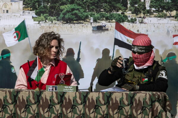 Fotografía de una representante de la Cruz Roja y un combatiente palestino de las Brigadas Izz ad-Din al-Qassam de Hamas. EFE/EPA/HAITHAM IMAD