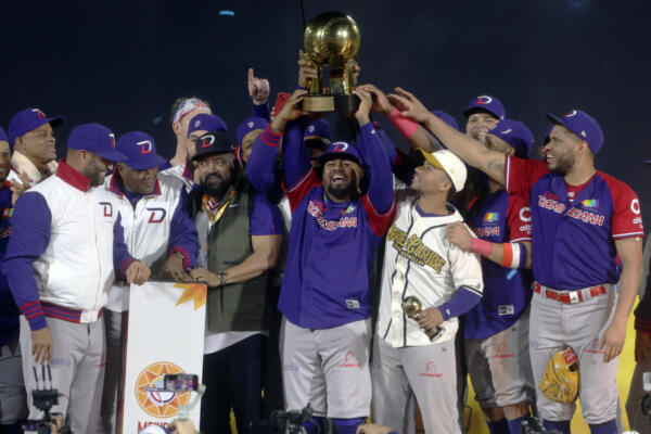 Players from Dominican Republic's Leones del Escogido hold the trophy after their victory over Mexico's Charros de Jalisco in the Caribbean Series baseball tournament first place play-off game between Dominican Republic and Mexico at Estadio El Nido De Los Aguilas in Mexicali, Baja California state, Mexico on February 8, 2025. (Photo by FAUSTO IBARRA / AFP)