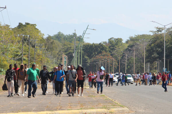 Migrantes caminan después de regresar de la Comisión Mexicana de Ayuda a Personas Refugiadas (Comar), en espera de resolver su situación migratoria este jueves en la ciudad de Tapachula en el estado de Chiapas (México)