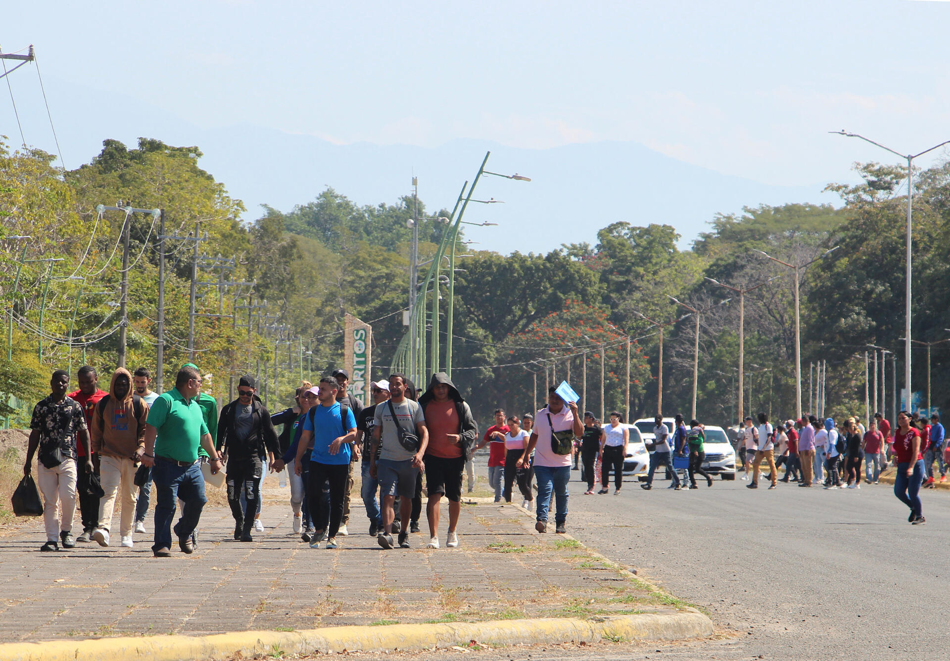 Migrantes caminan después de regresar de la Comisión Mexicana de Ayuda a Personas Refugiadas (Comar), en espera de resolver su situación migratoria este jueves en la ciudad de Tapachula en el estado de Chiapas (México)