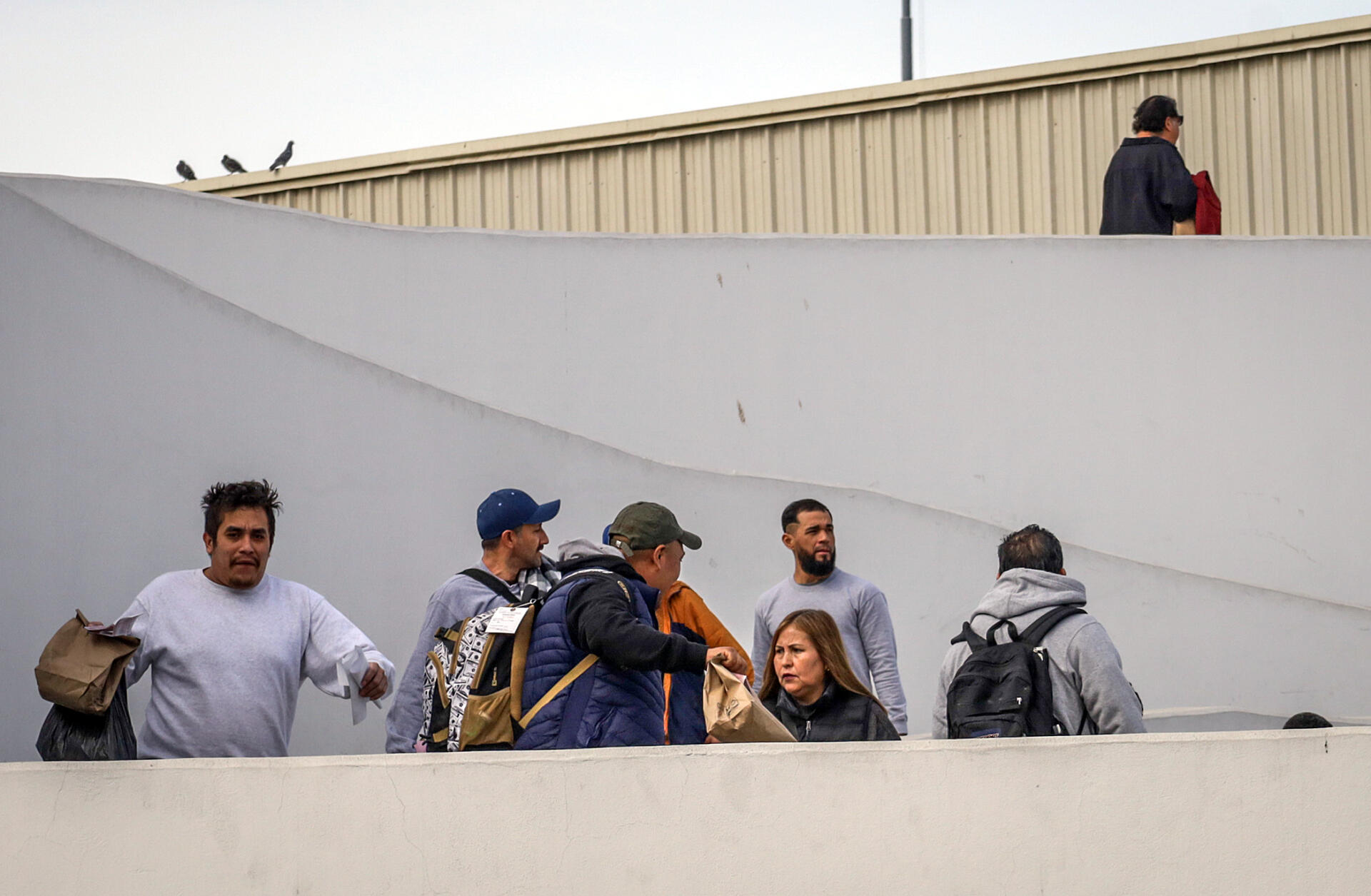 Migrantes deportados ayer, son vistos en el puerto fronterizo de El Chaparral, en Tijuana (México)