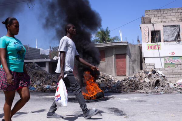 Personas caminan cerca de una barricada en la zona de Tabarre durante una nueva jornada de movilizaciones contra la inseguridad, en Puerto Príncipe (Haití). EFE/ Mentor David Lorens
