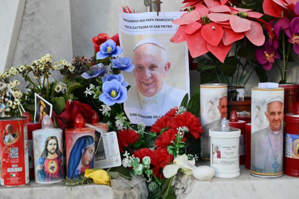 Se colocan velas, flores y un retrato del Papa Francisco frente a la estatua de Juan Pablo II afuera del hospital Gemelli. Alberto PIZZOLI / AFP