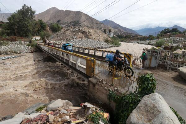 Fotografía cedida por la Agencia Andina de Perú de personas pasando un puente sobre el río Rimac en el distrito de Chosica al este de Lima. EFE/ Agencia Andina de Perú