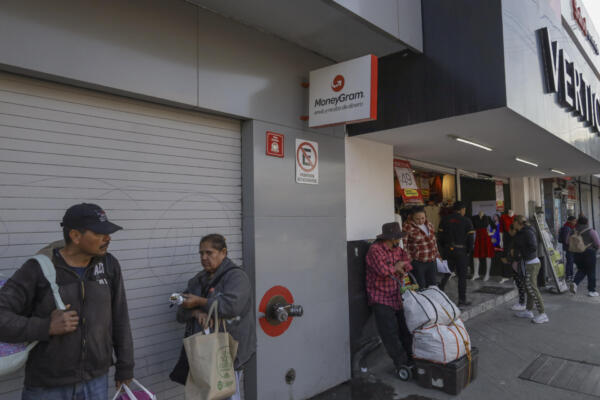 Personas esperan afuera de un establecimiento de envío de dinero este lunes en la ciudad de Tijuana, en Baja California (México). EFE/ Joebeth Terríquez