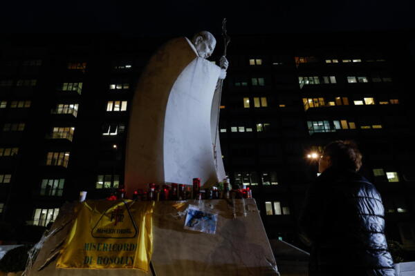 Mujer reza ante estatua de Juan Pablo II en entrada del Hospital Agostino Gemelli, donde el Papa Francisco permanece hospitalizado, en Roma, Italia. EFE/EPA/GIUSEPPE LAMI