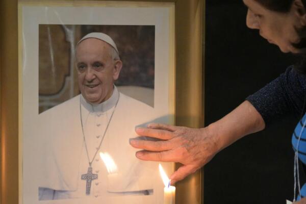 
Un fiel toca un retrato del Papa Francisco durante una misa en la Basílica San José de Flores para orar por su salud en Buenos Aires el 19 de febrero de 2025. (Foto de JUAN MABROMATA / AFP)