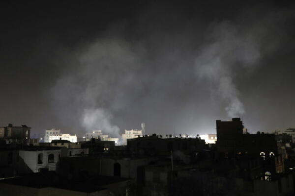 El humo que se elevó sobre un perfil de un grupo de edificios de Saná fue registrado en la madrugada de este 27 de marzo, tras varios ataques aéreos de EE.UU., en la capital de Yemen. EFE/Osamah Yahya