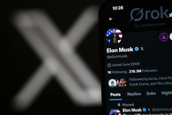 Una fotografía ilustrativa muestra la cuenta X de Elon Musk en la pantalla de un teléfono junto al logotipo X. AFP