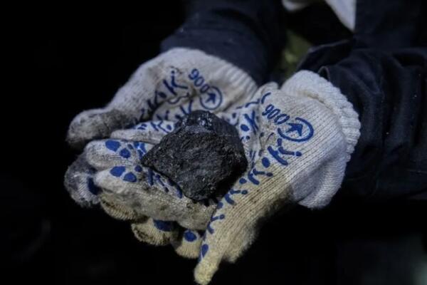 Un operario muestra un trozo del mineral extraído de una mina en Dnipropetrovsk. EFE/María Senovilla
