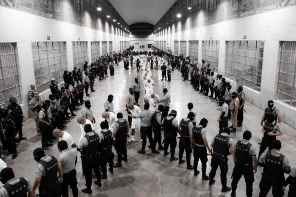 Guardias del Centro de Confinamiento del Terrorismo, trasladando a supuestos miembros de la banda: Tren de Aragua, en el Salvador). EFE/ Presidencia de El Salvador