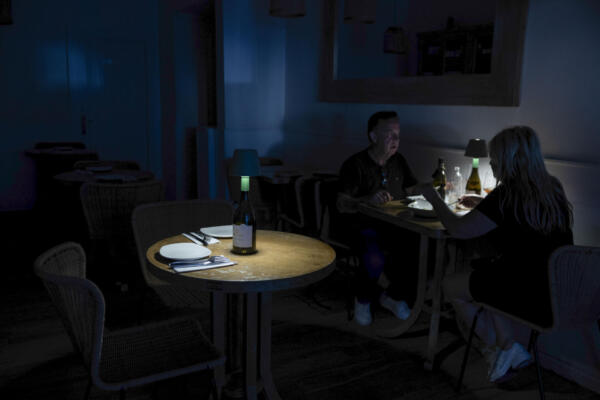 Una pareja cena en un restaurante del centro de Málaga este lunes, durante la caída de la red eléctrica en toda la península. 