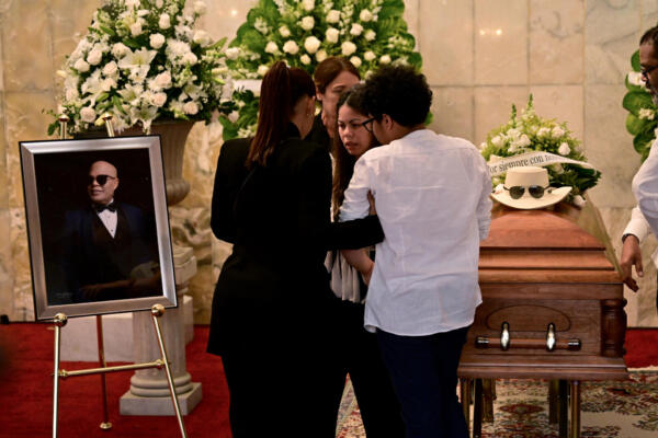 La hija de Rubby Pérez, Zulinka Pérez, y otros familiares junto al ataúd del famoso merenguero, quien falleció tras el derrumbe del techo de la discoteca Jet Set (Foto de Martin BERNETTI / AFP)