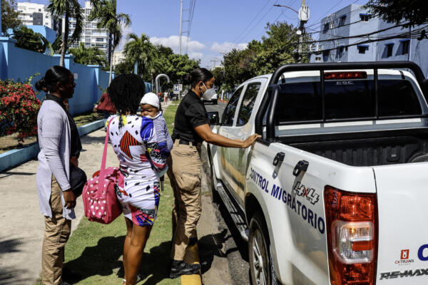 Mujeres haitianas son trasladadas por agentes de migración a una patrulla frente a un hospital en Santo Domingo el 21 de abril de 2025. AFP