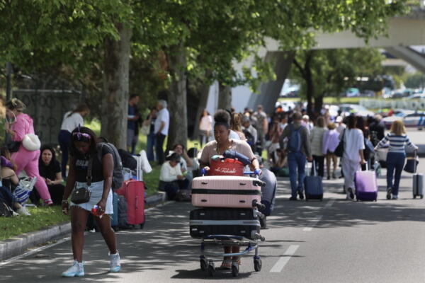 Los viajeros caminan hacia las salidas en el aeropuerto Humberto Delgado de Lisboa, ya que la zona está cerrada debido al apagón que afecta a España y Portugal, en Lisboa, Portugal, 28 de abril de 2025. EFE