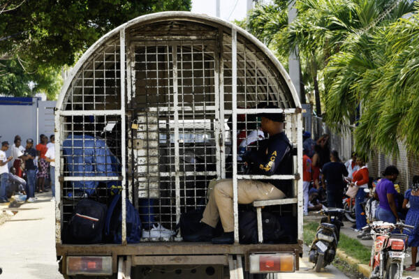 Hombres haitianos dentro de una patrulla de inmigración son fotografiados frente a un hospital en Santo Domingo el 21 de abril de 2025. AFP
