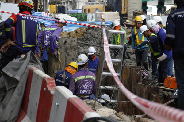 Rescatistas y obreros participan en una operación para rescatar a un trabajador que cayó en un socavón de 19 metros de profundidad en una obra de metro en Bangkok. EFE/EPA/NARONG SANGNAK