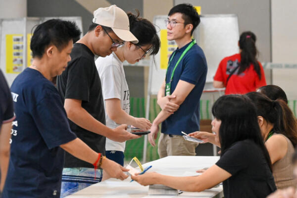 La gente se registra para votar en las elecciones generales en un colegio electoral de Singapur el 3 de mayo de 2025. Los colegios electorales abrieron el 3 de mayo en todo Singapur, cuando los votantes comenzaron a emitir su voto en unas elecciones consideradas la primera prueba real para el primer ministro Lawrence Wong y su Partido de Acción Popular, que gobierna desde hace tiempo. (Foto de Roslan RAHMAN / AFP)

