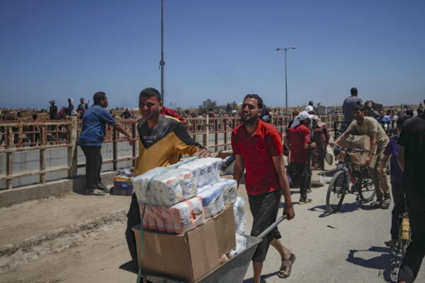 Palestinos transportan suministros de ayuda recibidos de la Gaza Humanitarian Foundation, respaldada por Estados Unidos, a través de una zona conocida como el Corredor Netzarim, en el centro de la Franja de Gaza, el 29 de mayo de 2025. EFE/HAITHAM IMAD