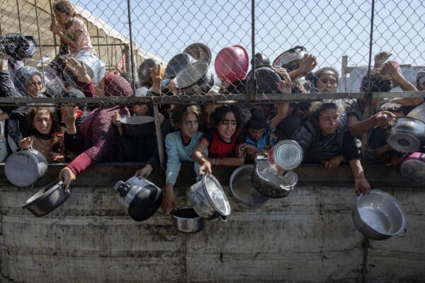 Palestinos desplazados fueron captados este viernes, 30 de mayo, al agolparse frente a un comedor social, en Khan Younis, sur de la Franja de Gaza. EFE