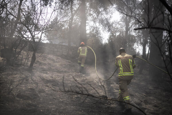 Bomberos israelíes ayudan a extinguir un incendio cerca del Monasterio de Latrún, en el centro de Israel, el 1 de mayo de 2025. AFP