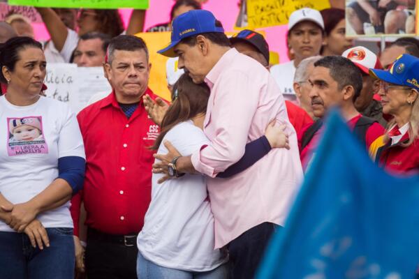 El presidente de Venezuela, Nicolás Maduro, abraza a la madre de Maikelys Espinoza, Yorely Bernal (c), en una manifestación por el Día Internacional del Trabajador. EFE/ Miguel Gutiérrez