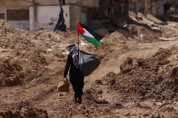 Un hombre palestino que camina frente a la entrada principal del campo de refugiados de Tulkarem en la ciudad cisjordana de Tulkarem. EFE