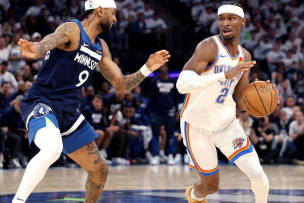 Shai Gilgeous-Alexander ataca por Oklahoma City Thunder frnete a la defensa de su primo Nikel Alexander-Walker de Minnesota Timberwolves