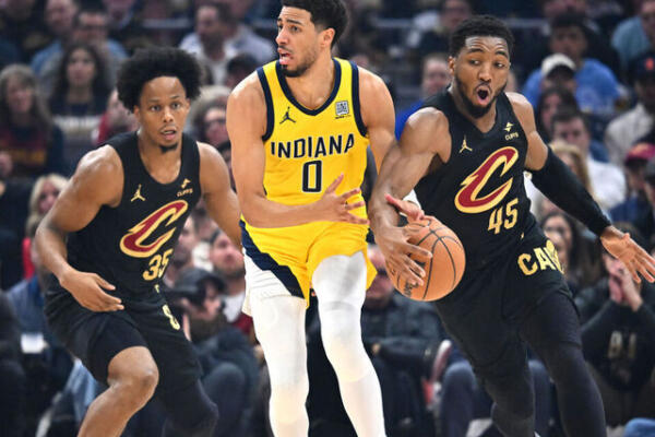 Tyrese Haliburton de Indiana Pacers, maneja la pelota, ante la defensa de los jugadores de Cleveland Donovan Mitchell e Isaac Okoro