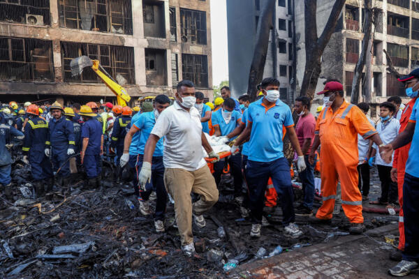 Los rescatistas transportan el cuerpo de una víctima en el lugar donde se estrelló el vuelo 171 de Air India en una zona residencial cerca del aeropuerto de Ahmedabad el 12 de junio de 2025. (Foto de Sam PANTHAKY / AFP)