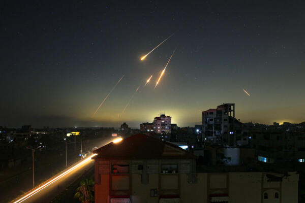 This picture taken from Nuseirat, in the central Gaza Strip, shows rocket trails in the sky late on June 13, 2025, after Iran struck Israel with barrages of missiles after a massive onslaught targeted the Islamic republic's nuclear and military facilities. (Photo by Eyad BABA / AFP)