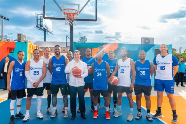 El presidente ejecutivo del Banco Popular, señor Christopher Paniagua, junto a empleados del equipo de baloncesto de la institución.
