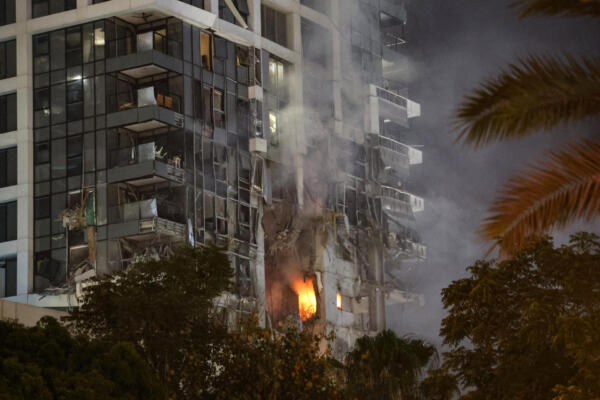 Fuego y humo se elevan desde un edificio, presuntamente alcanzado por un misil lanzado desde Irán, en el centro de Tel Aviv el 13 de junio de 2025. AFP
