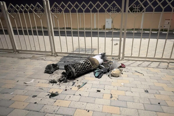 Restos de un misil iraní interceptado sobre Qatar, mientras yace en una acera cerca de una valla el 23 de junio de 2025.