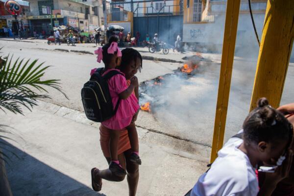 La gente huye de la violencia de pandillas en un barrio de Puerto Príncipe mientras se manifiesta contra el gobierno el 20 de febrero de 2025. AFP