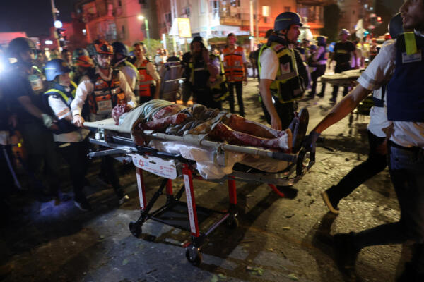 Personal de primera respuesta israelí evacuó a un hombre herido de una zona alcanzada por un misil lanzado desde Irán, en Ramat Gan, cerca de Tel Aviv, el 13 de junio de 2025. AFP