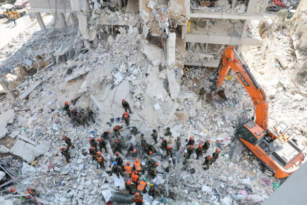 Equipos de rescate este domingo en el lugar del impacto de un misil en el centro de Israel tras un ataque de Irán. EFE