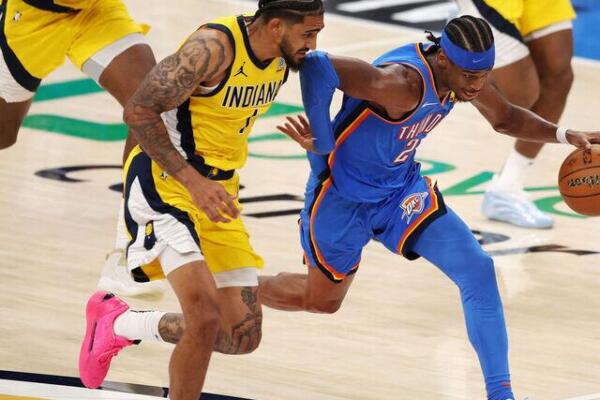 Shai Gilgeous-Alexander de Oklahoma City Thunder ataca, ante la marca de Obi Topin de Indiana Pacers en el juego 2 de la final de la NBA