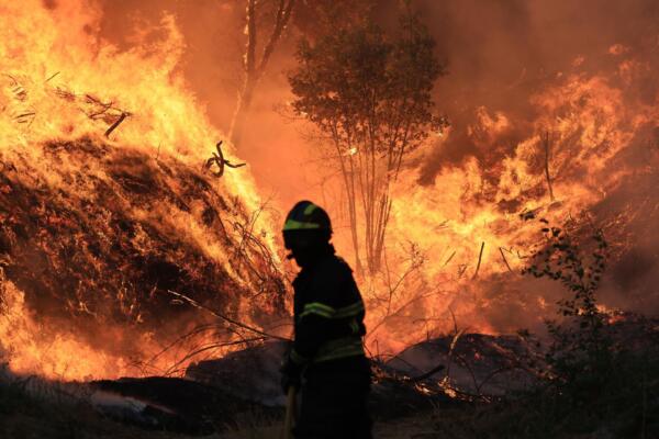 Un bombero lucha contra el fuego en Mocao, Santa Eulalia, Arouca, Portugal. EFE/ESTELA SILVA